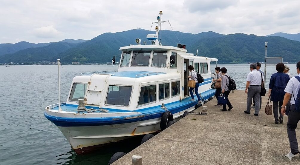 琵琶湖の堀切港に停泊し、乗客が乗り込んでいる「おきしま通船」の小型フェリー。