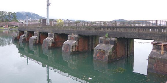 琵琶湖から瀬田川への流出量を調節する巨大な「瀬田川洗堰」の全景。ゲートから水が放流されている。