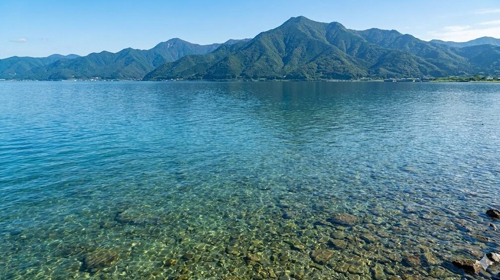 琵琶湖北湖の透明度の高い水と、遠くにそびえる山々の雄大な風景