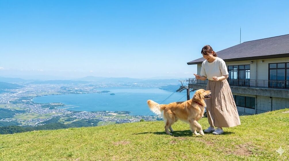 びわ湖バレイの山頂にある天空のドッグランからの絶景。眼下に琵琶湖を見下ろしながら、飼い主とゴールデンレトリバーが遊んでいる。