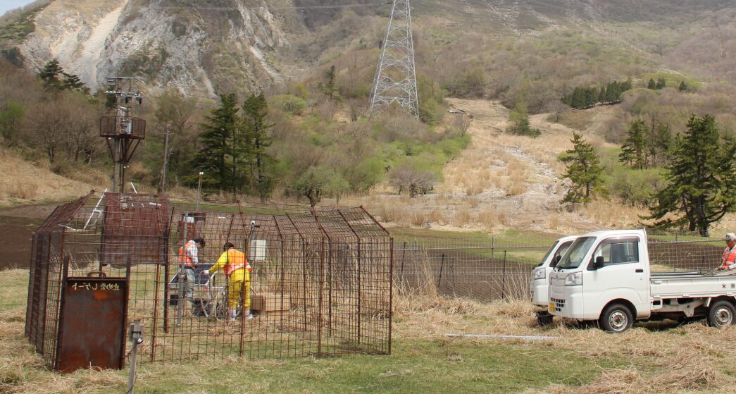 伊吹山山頂付近の防護柵。柵の内側はお花畑が保護され咲き乱れているが、外側は鹿の食害で裸地化している対比的な様子。