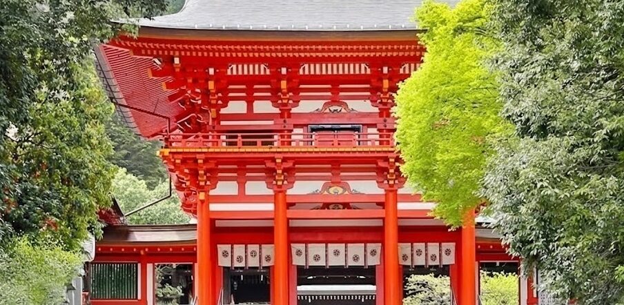 滋賀県大津市にある近江神宮の朱塗りの楼門。競技かるたの聖地として知られ、『ちはやふる』の舞台でもある象徴的な建物。